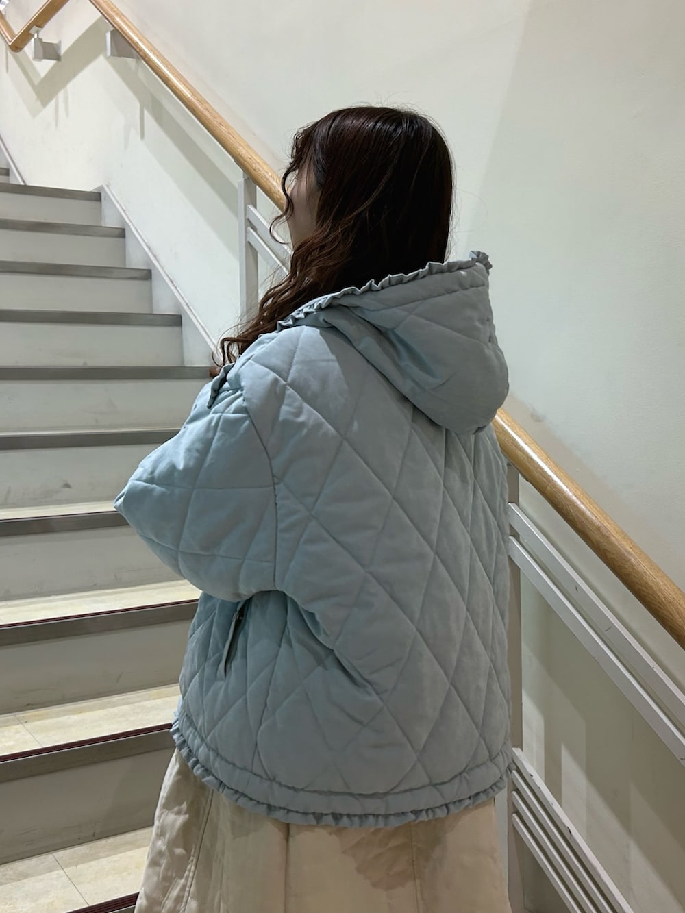 ピンク系のニット/セーター、ブルー系のダウンジャケット/コート、ホワイト系のワンピースを着用したレディースの冬コーディネートの6枚目の写真