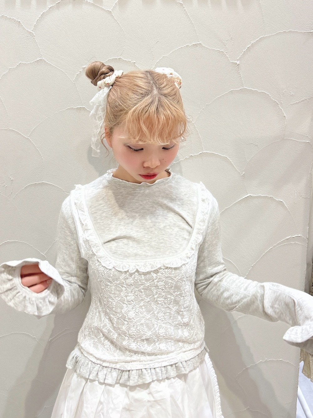 グレー系のTシャツ/カットソー、ホワイト系のスカート、ホワイト系のスニーカーを着用したレディースの冬コーディネートの5枚目の写真