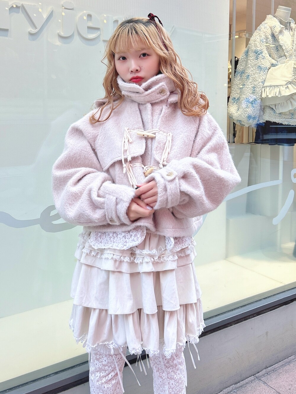 ホワイト系のスカート、ピンク系のダッフルコート、ホワイト系のカーディガン/ボレロを着用したレディースの秋コーディネートの5枚目の写真