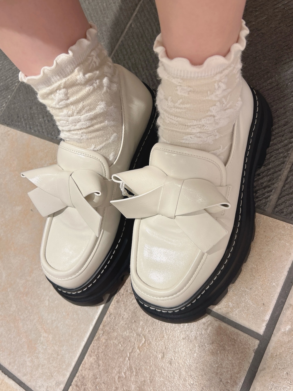 ホワイト系のワンピース、ホワイト系のローファーを着用したレディースの秋コーディネートの10枚目の写真