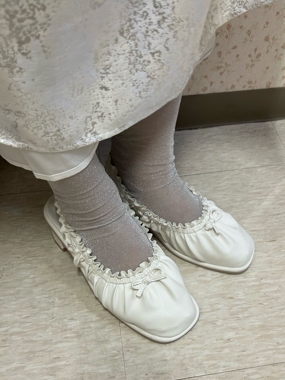 ホワイト系のスウェット、ホワイト系のスカート、ホワイト系のパンプスを着用したレディースの冬コーディネートの7枚目の写真