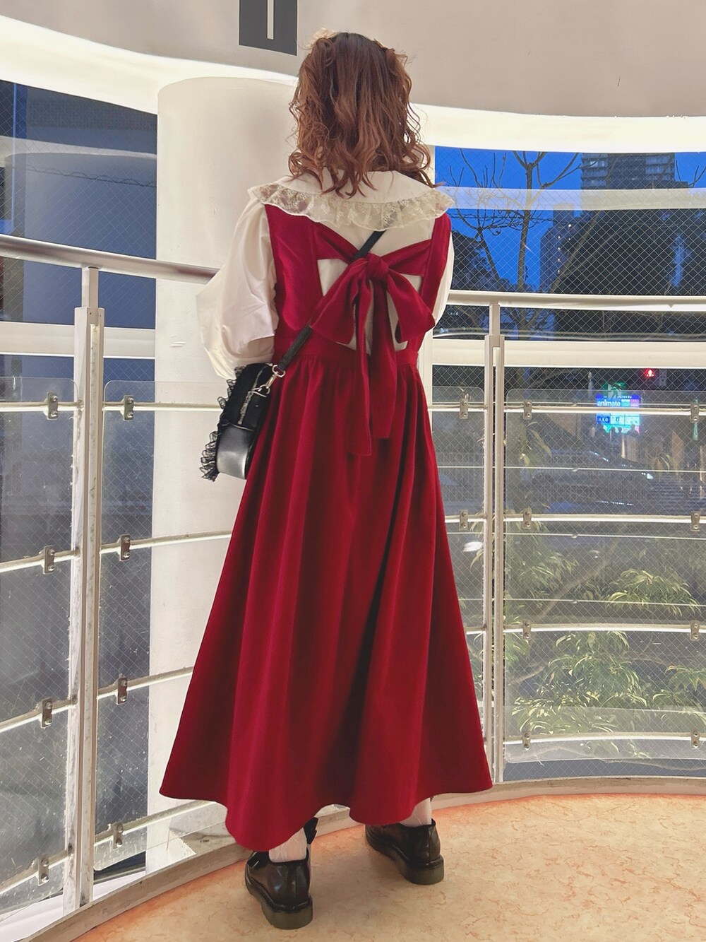 レッド系のワンピース、ゴールド系のシャツ/ブラウス、ブラック系のショルダーバッグを着用したレディースの秋コーディネートの2枚目の写真