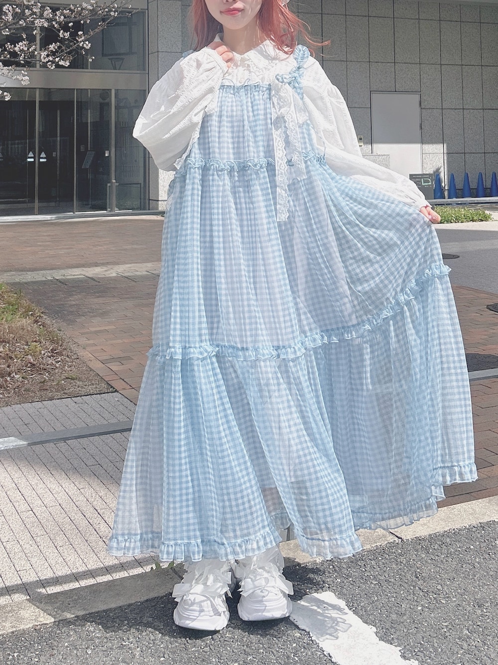 ブルー系のワンピース、ホワイト系のシャツ/ブラウス、ホワイト系のスニーカーを着用したレディースの春コーディネートの2枚目の写真