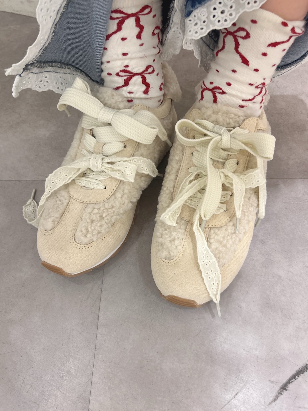 グリーン系のワンピース、ホワイト系のジャージ、ブルー系のデニムパンツを着用したレディースの秋コーディネートの10枚目の写真