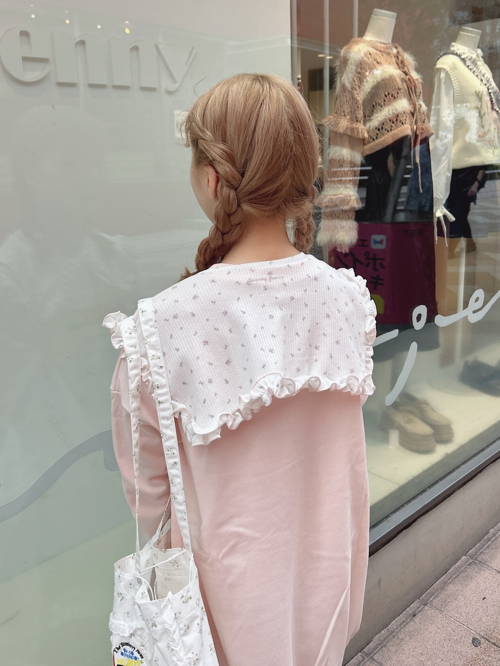 ピンク系のスウェット、ブルー系のデニムパンツ、ホワイト系のトートバッグを着用したレディースの秋コーディネートの5枚目の写真