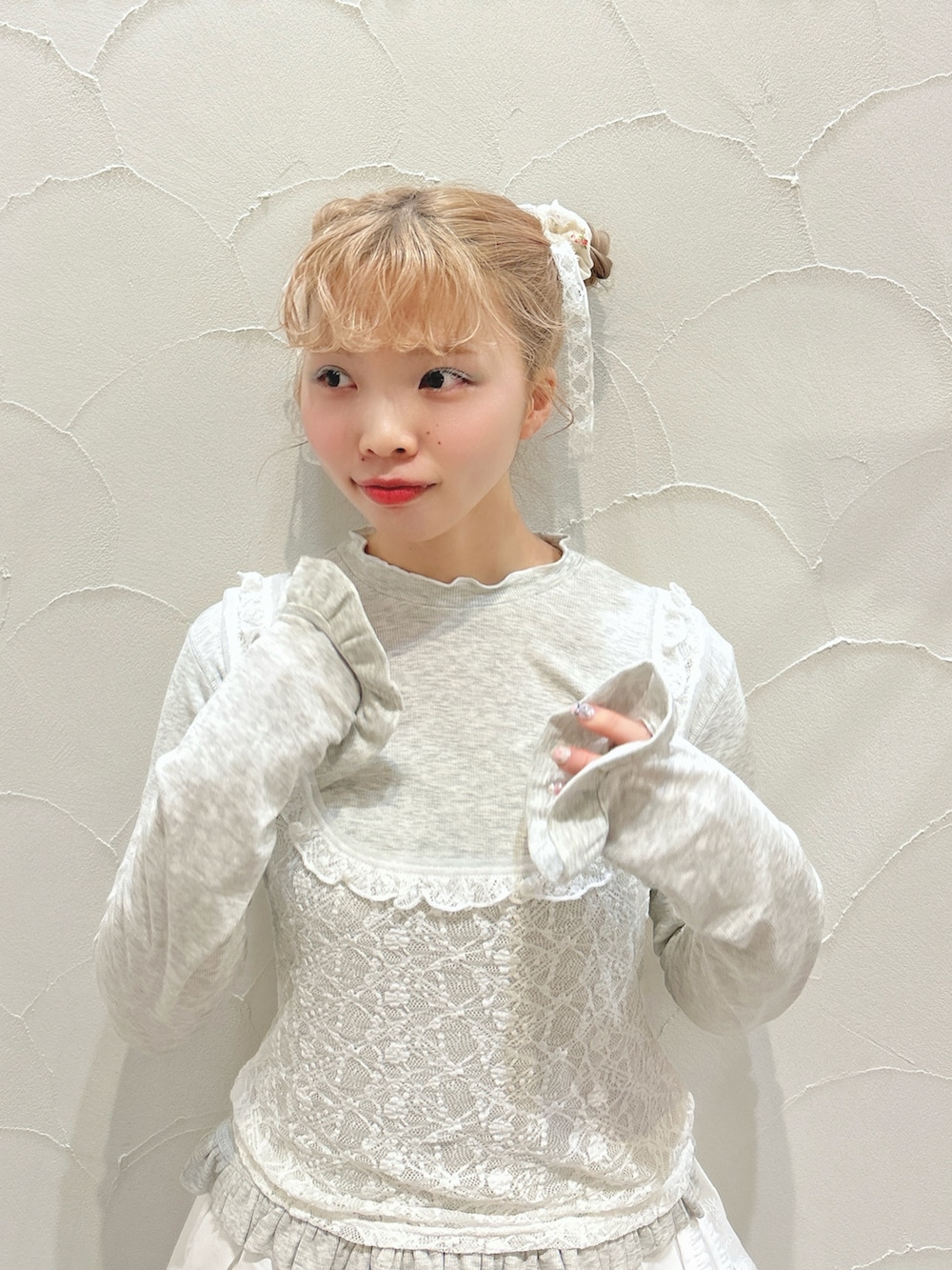 グレー系のTシャツ/カットソー、ホワイト系のスカート、ホワイト系のスニーカーを着用したレディースの冬コーディネートの7枚目の写真