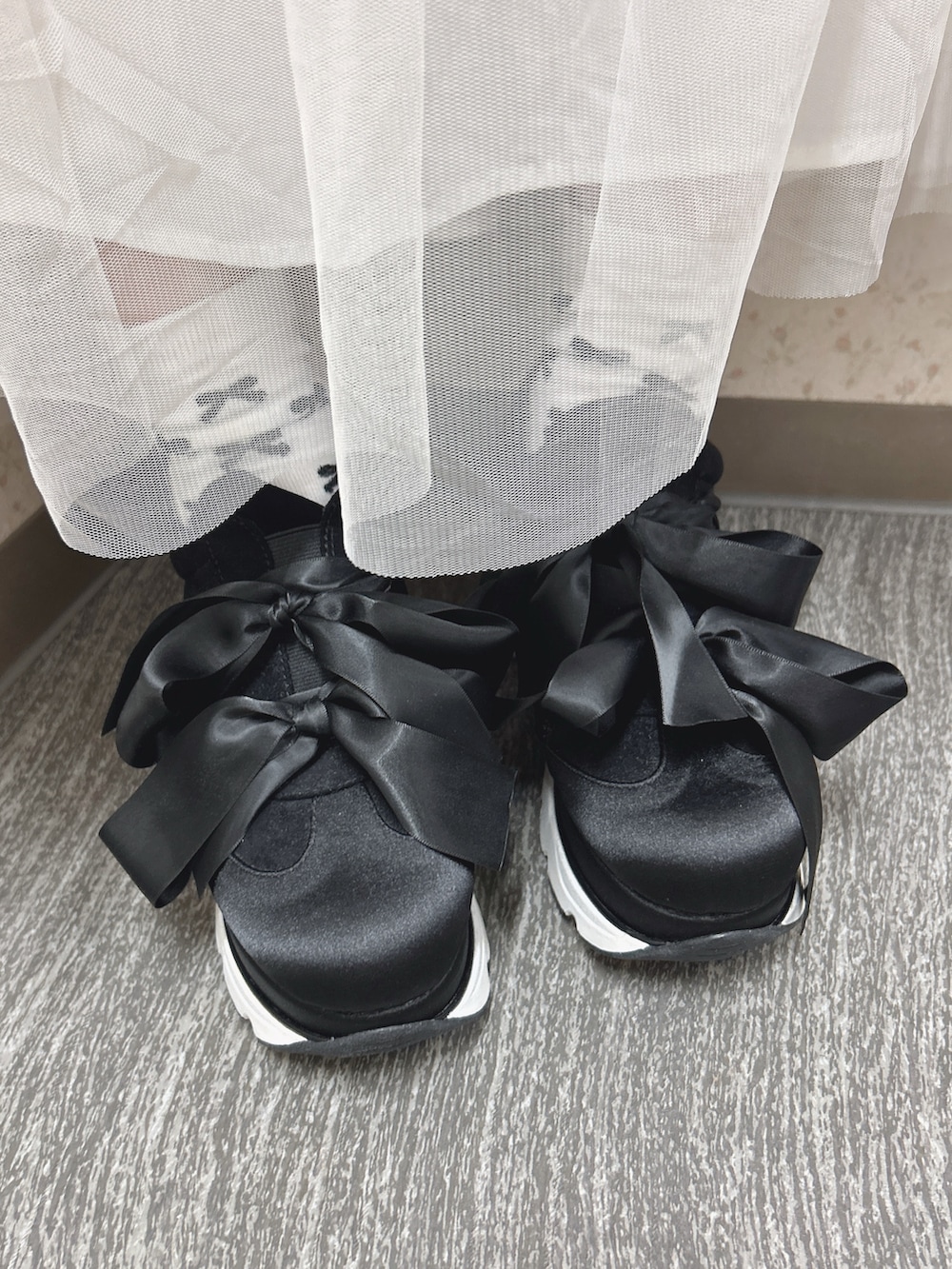 レッド系のニット/セーター、ホワイト系のワンピース、ブラック系のトートバッグを着用したレディースの秋コーディネートの10枚目の写真