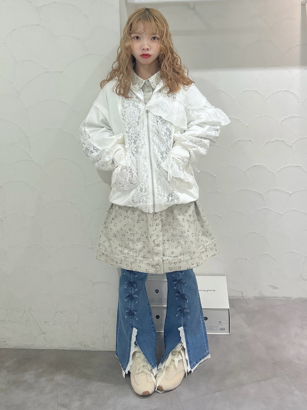 グリーン系のワンピース、ホワイト系のジャージ、ブルー系のデニムパンツを着用したレディースの秋コーディネートの4枚目の写真