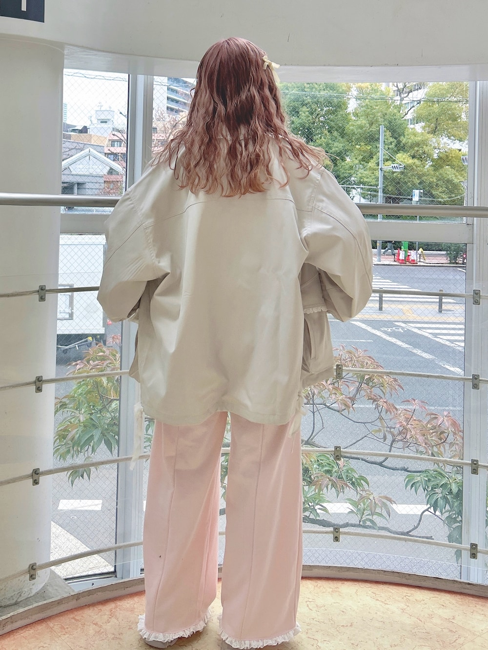 ホワイト系のブルゾン、グリーン系のTシャツ/カットソー、ピンク系のスウェットパンツを着用したレディースの冬コーディネートの4枚目の写真