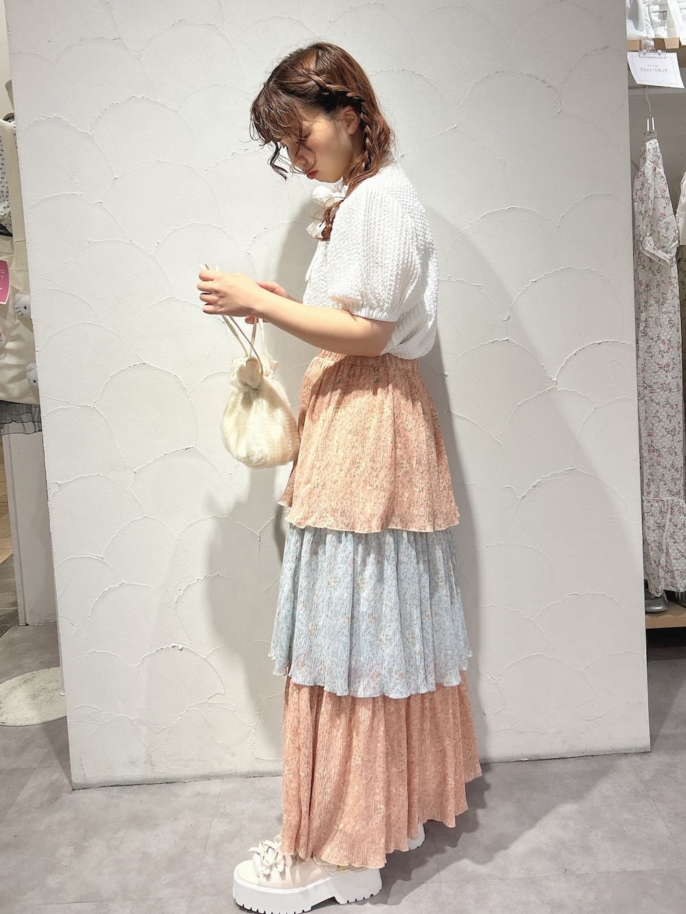 ピンク系のスカート、ホワイト系のシャツ/ブラウス、ホワイト系のショルダーバッグを着用したレディースの夏コーディネートの2枚目の写真