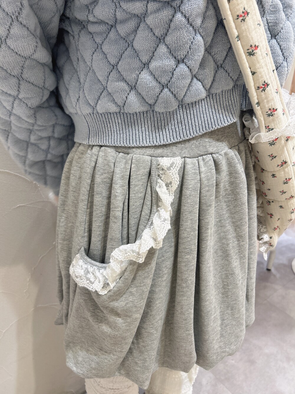 ブルー系のカーディガン/ボレロ、ピンク系のニット/セーター、グレー系のスカートを着用したレディースの冬コーディネートの8枚目の写真