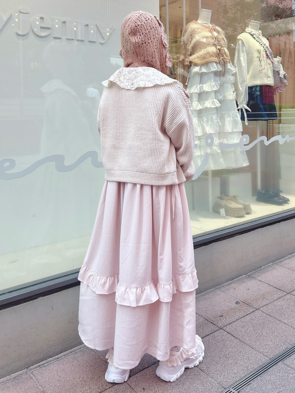 ピンク系のワンピース、ホワイト系のカーディガン/ボレロ、ピンク系のハンドバッグを着用したレディースの秋コーディネートの2枚目の写真