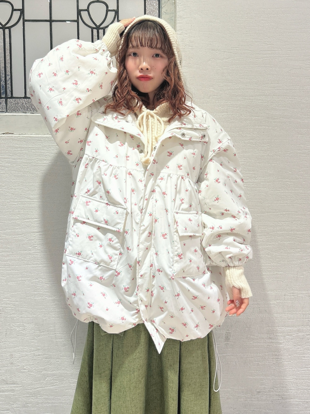 ピンク系のブルゾン、ホワイト系のニット/セーター、グリーン系のスカートを着用したレディースの秋コーディネートの7枚目の写真