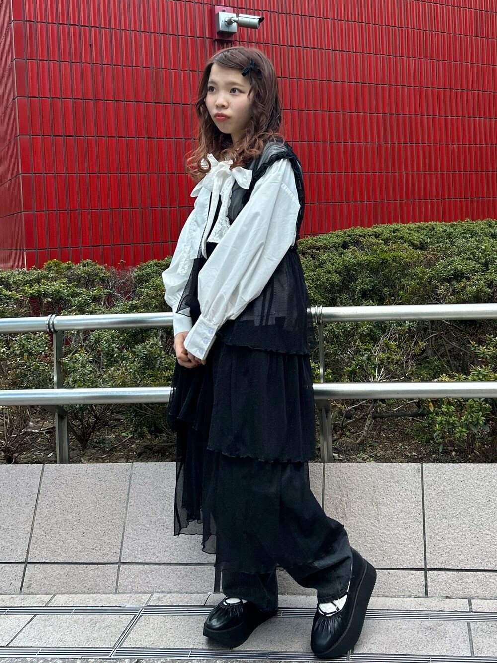 ホワイト系のシャツ/ブラウス、ブラック系のワンピース、ブラック系のデニムパンツを着用したレディースの冬コーディネートの5枚目の写真