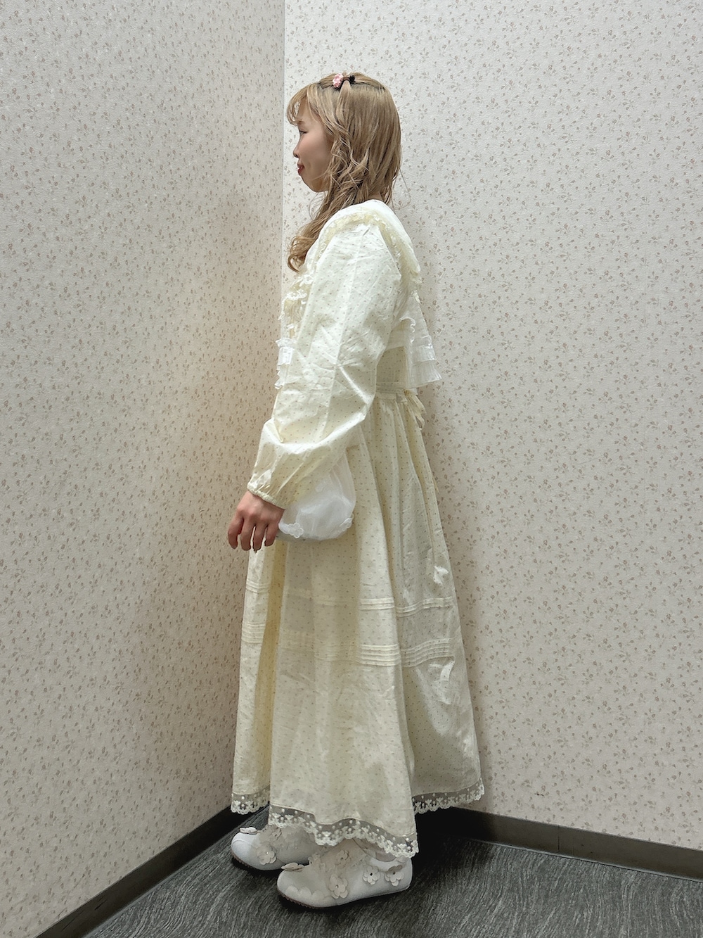 ベージュ系のワンピース、ホワイト系のハンドバッグ、ホワイト系のスニーカーを着用したレディースの冬コーディネートの3枚目の写真