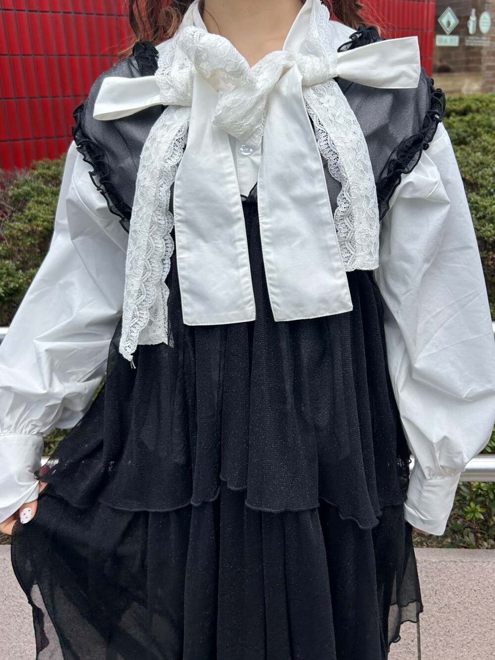 ホワイト系のシャツ/ブラウス、ブラック系のワンピース、ブラック系のデニムパンツを着用したレディースの冬コーディネートの9枚目の写真