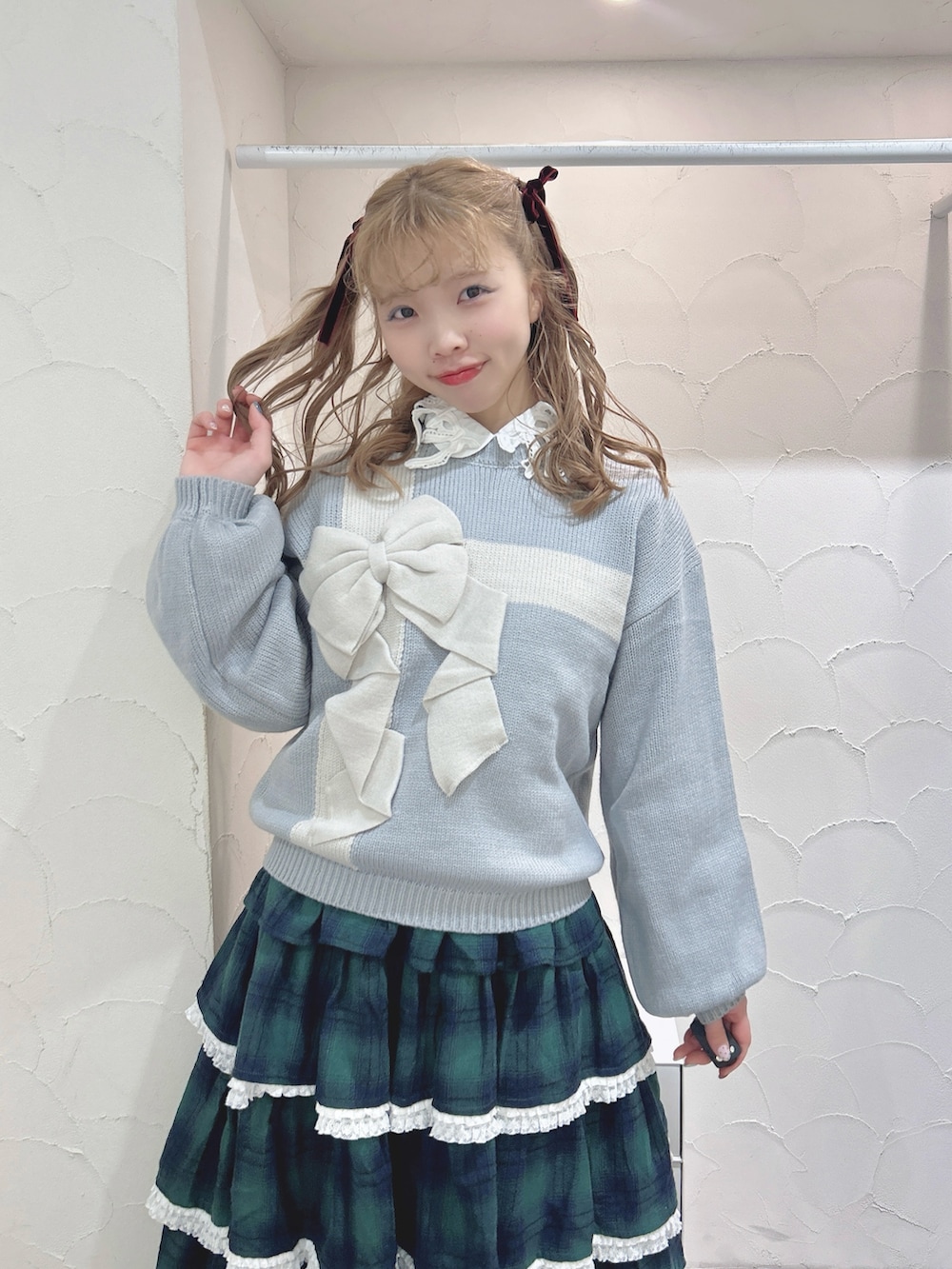 ブルー系のニット/セーター、ホワイト系のシャツ/ブラウス、グリーン系のスカートを着用したレディースの秋コーディネートの7枚目の写真