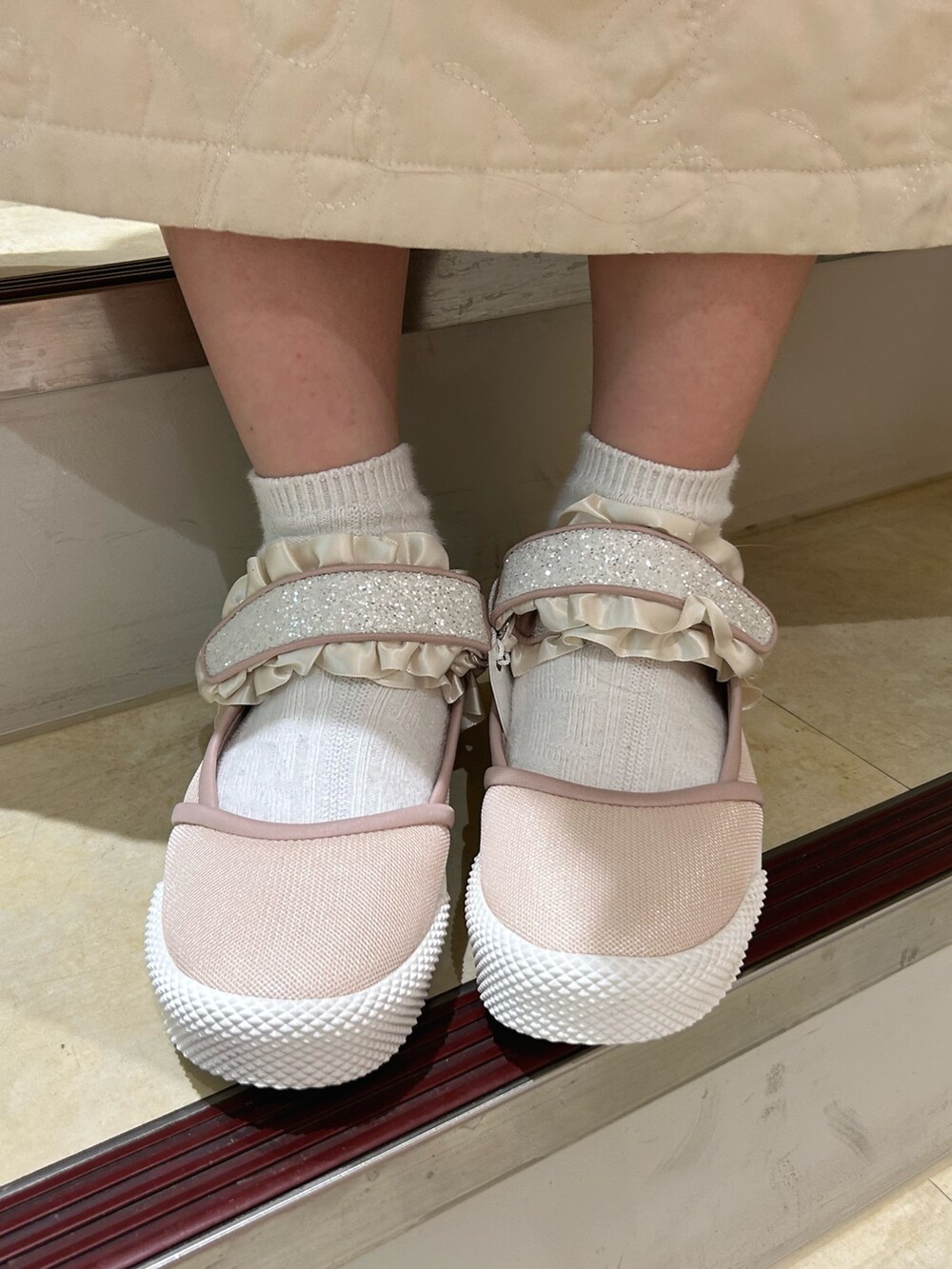 ピンク系のニット/セーター、ブルー系のダウンジャケット/コート、ホワイト系のワンピースを着用したレディースの冬コーディネートの8枚目の写真