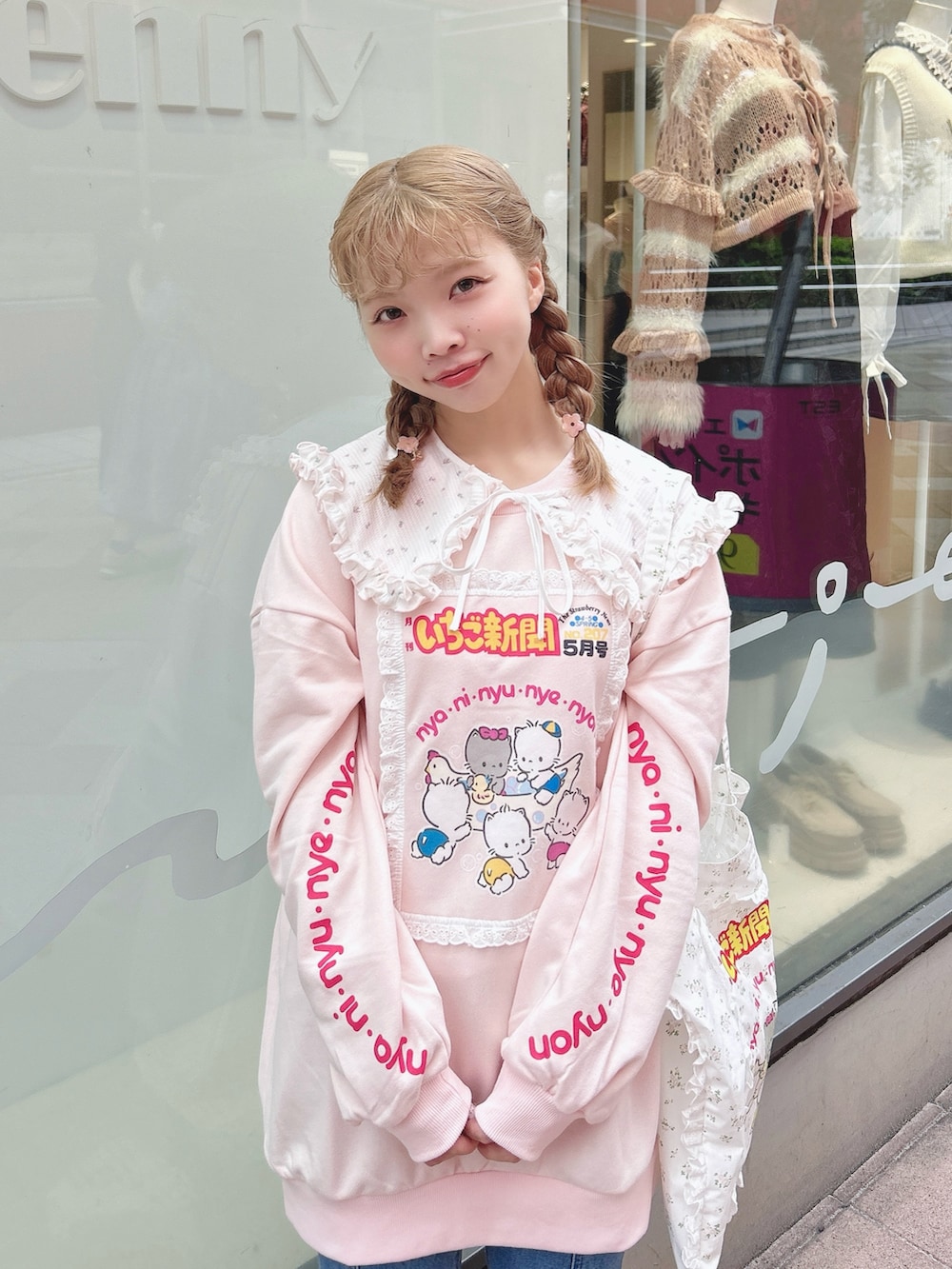 ピンク系のスウェット、ブルー系のデニムパンツ、ホワイト系のトートバッグを着用したレディースの秋コーディネートの4枚目の写真