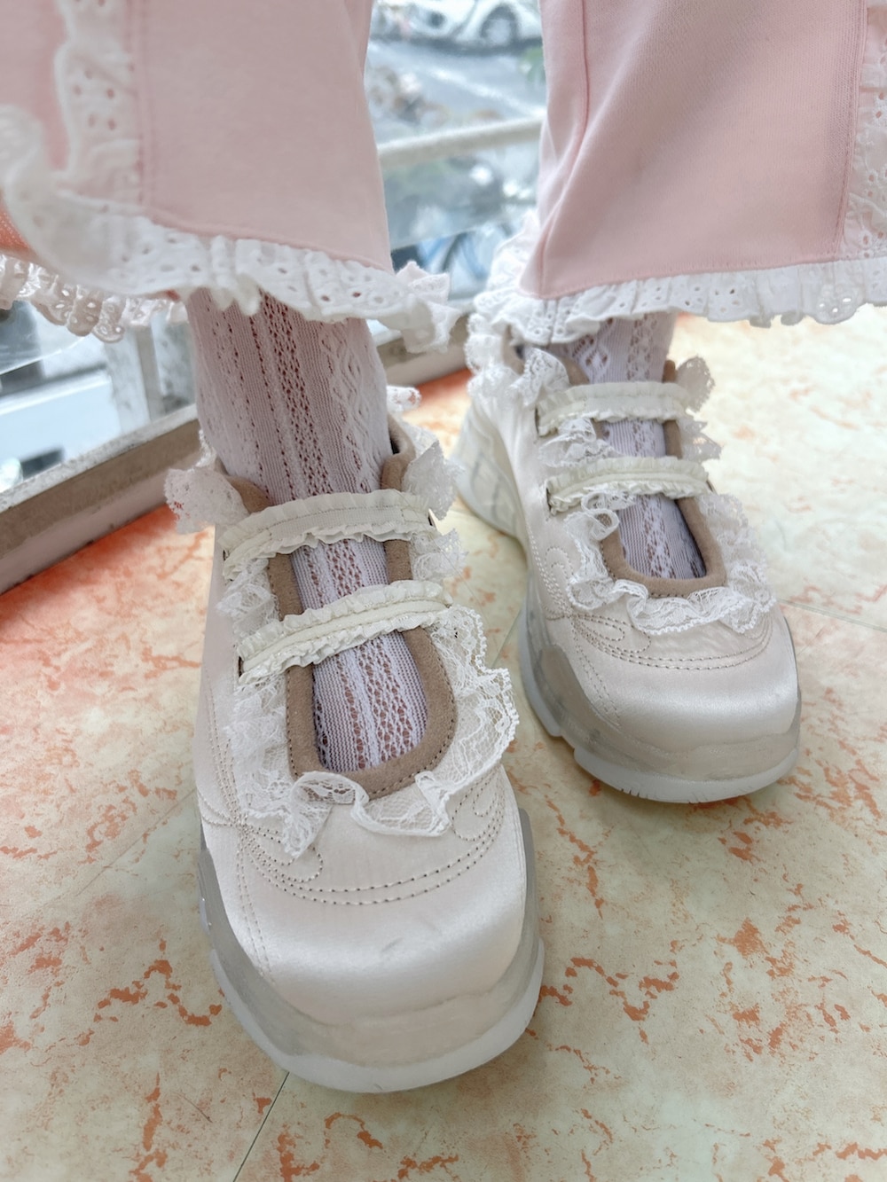 ホワイト系のブルゾン、グリーン系のTシャツ/カットソー、ピンク系のスウェットパンツを着用したレディースの冬コーディネートの10枚目の写真