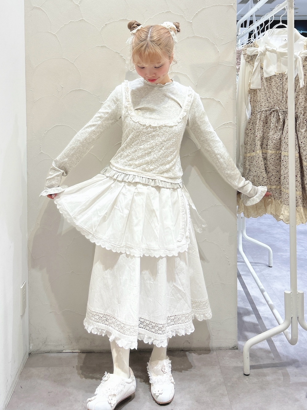 グレー系のTシャツ/カットソー、ホワイト系のスカート、ホワイト系のスニーカーを着用したレディースの冬コーディネートの2枚目の写真