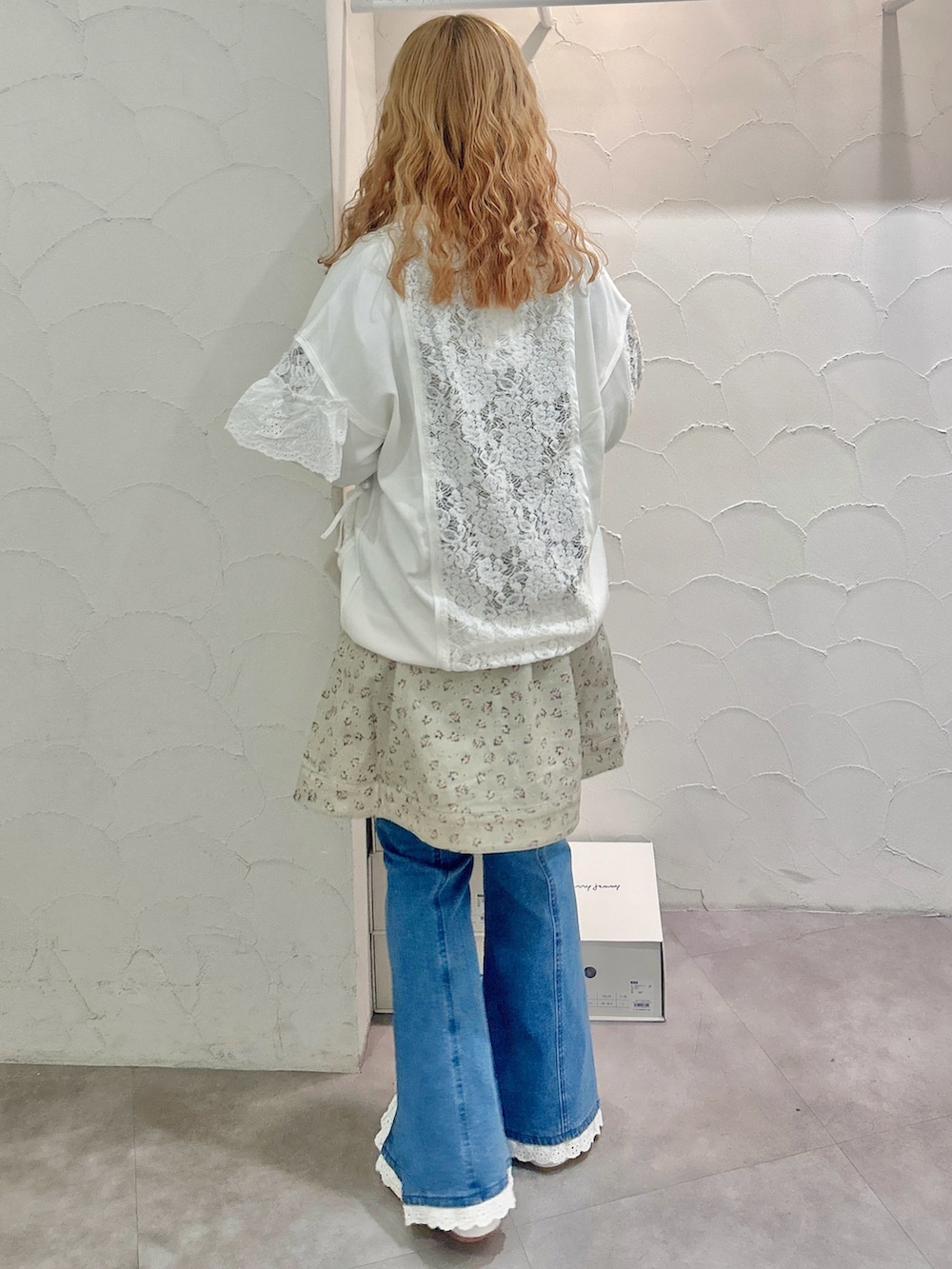 グリーン系のワンピース、ホワイト系のジャージ、ブルー系のデニムパンツを着用したレディースの秋コーディネートの3枚目の写真