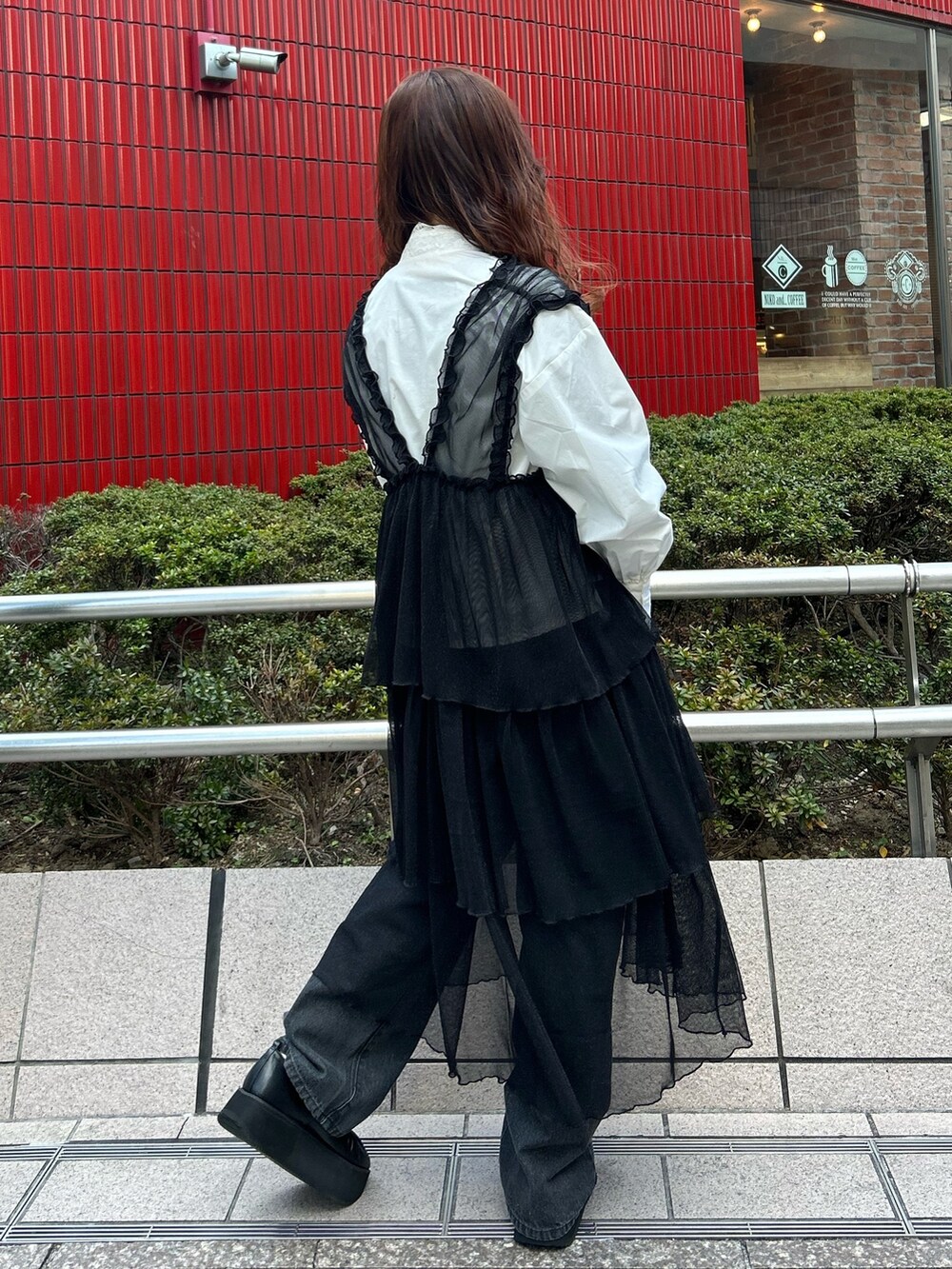 ホワイト系のシャツ/ブラウス、ブラック系のワンピース、ブラック系のデニムパンツを着用したレディースの冬コーディネートの4枚目の写真