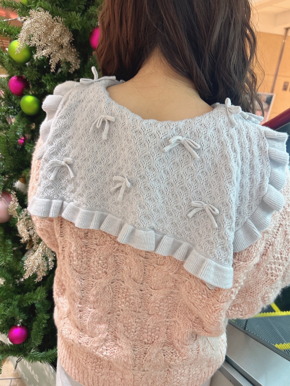 ピンク系のニット/セーター、ブルー系のワンピース、ブルー系のデニムパンツを着用したレディースの冬コーディネートの7枚目の写真