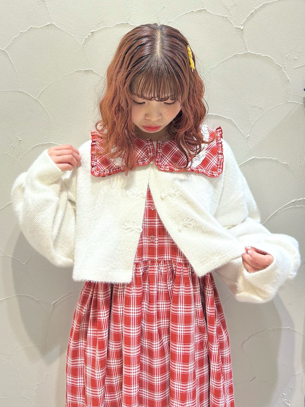 レッド系のワンピース、ホワイト系のカーディガン/ボレロ、ホワイト系のスニーカーを着用したレディースの秋コーディネートの4枚目の写真