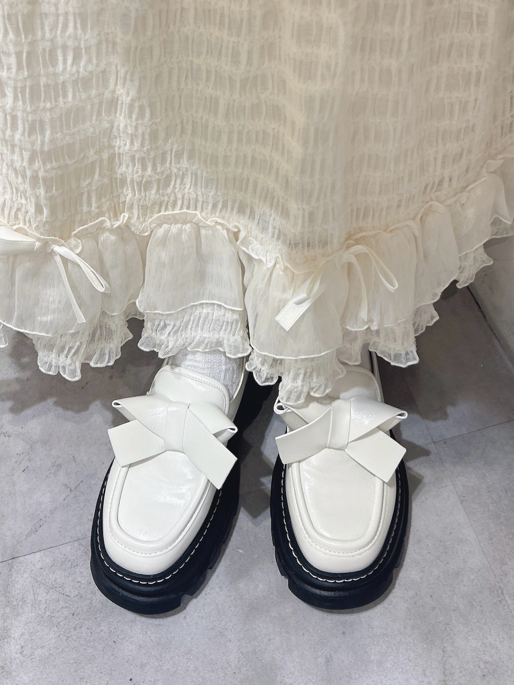 ホワイト系のシャツ/ブラウス、ホワイト系のベスト、ベージュ系のムートンコートを着用したレディースの冬コーディネートの9枚目の写真