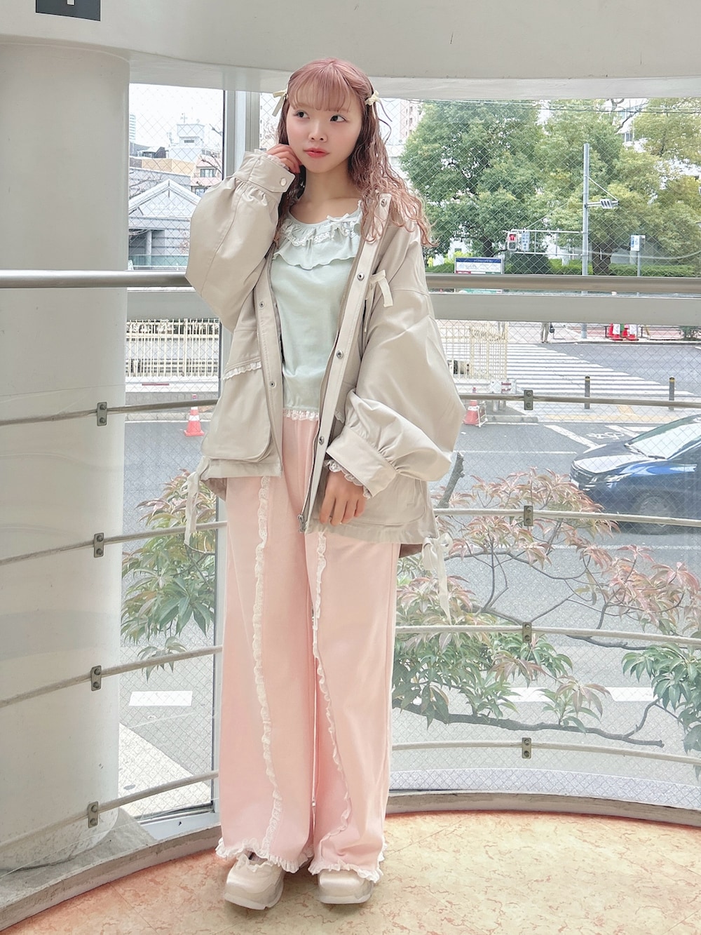 ホワイト系のブルゾン、グリーン系のTシャツ/カットソー、ピンク系のスウェットパンツを着用したレディースの冬コーディネートの2枚目の写真