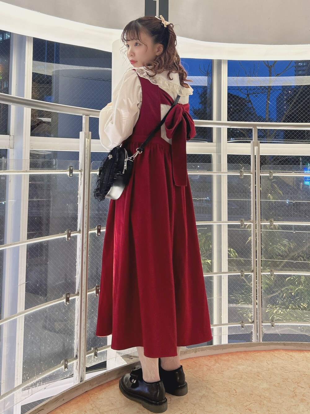 レッド系のワンピース、ゴールド系のシャツ/ブラウス、ブラック系のショルダーバッグを着用したレディースの秋コーディネートの3枚目の写真