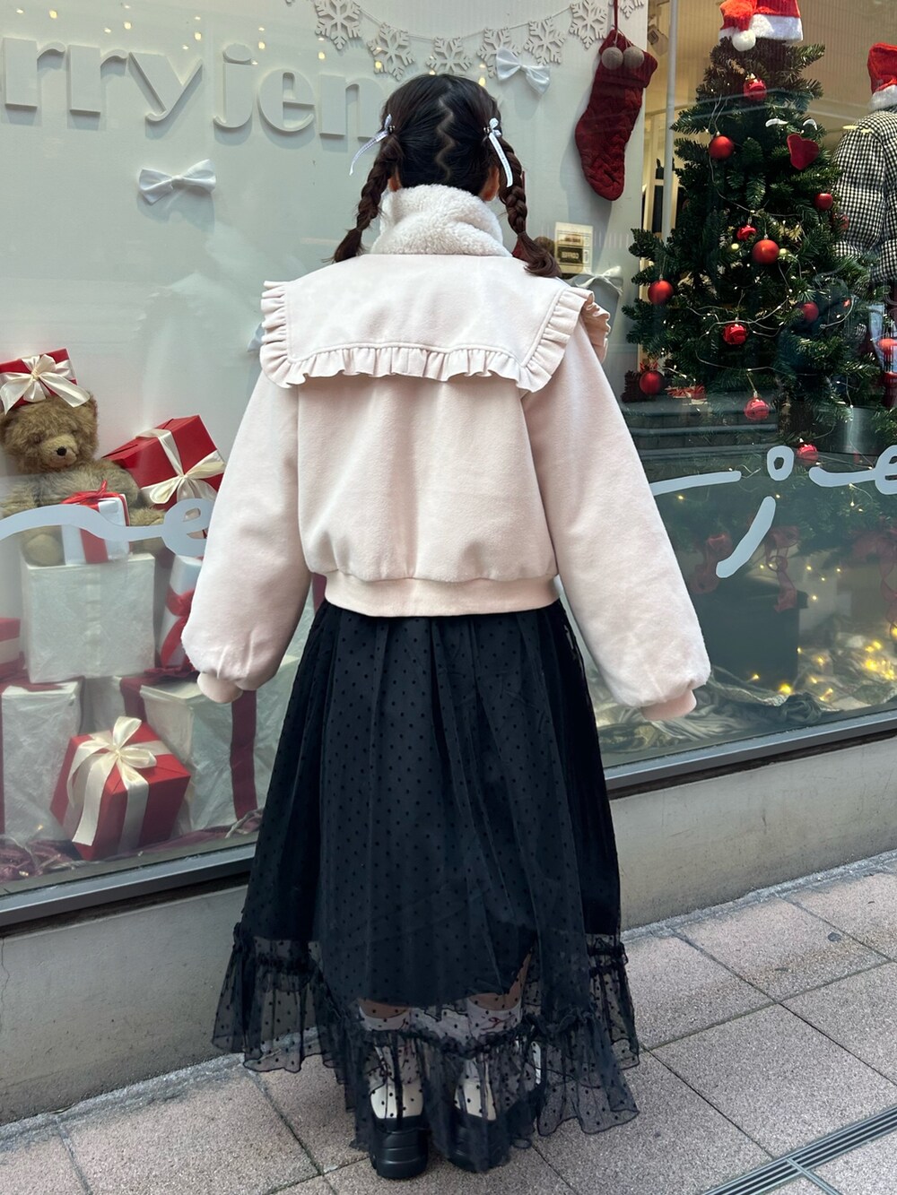 ホワイト系のブルゾン、レッド系のニット/セーター、ブラック系のワンピースを着用したレディースの冬コーディネートの2枚目の写真