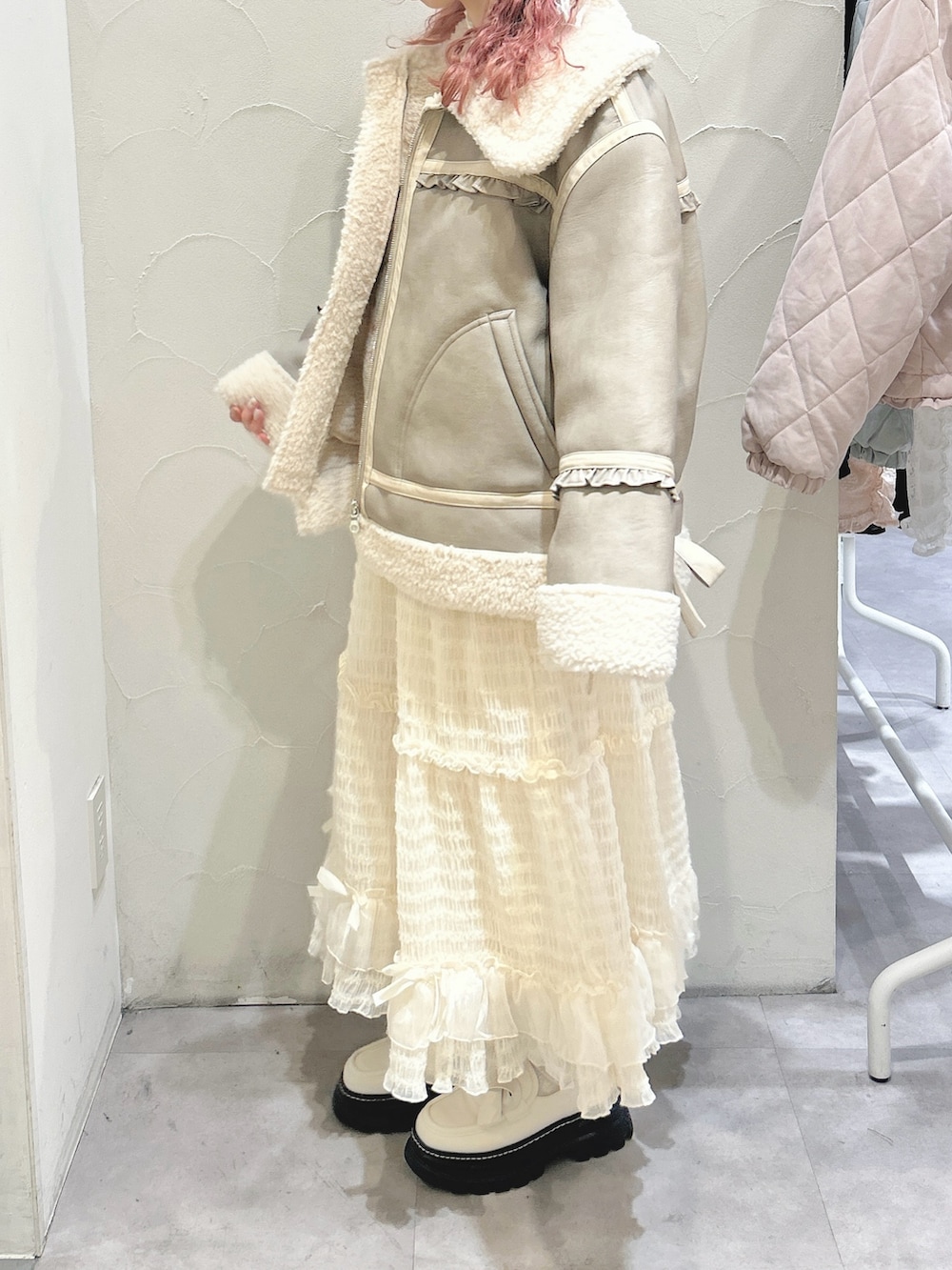 ホワイト系のシャツ/ブラウス、ホワイト系のベスト、ベージュ系のムートンコートを着用したレディースの冬コーディネートの3枚目の写真