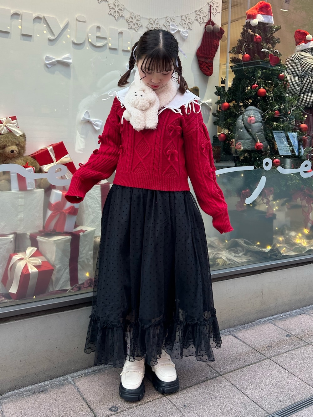 ホワイト系のブルゾン、レッド系のニット/セーター、ブラック系のワンピースを着用したレディースの冬コーディネートの7枚目の写真