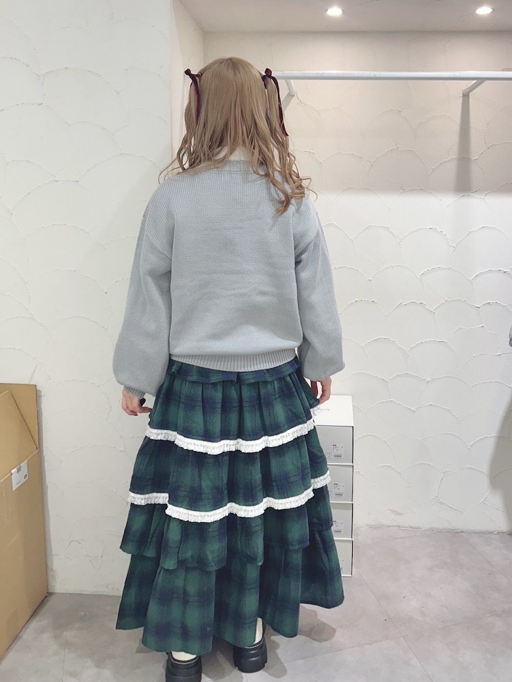 ブルー系のニット/セーター、ホワイト系のシャツ/ブラウス、グリーン系のスカートを着用したレディースの秋コーディネートの3枚目の写真