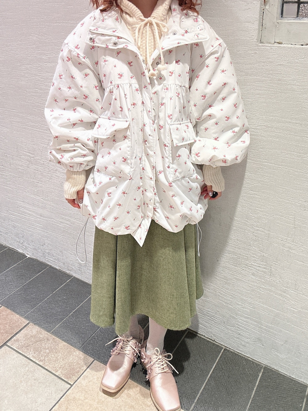 ピンク系のブルゾン、ホワイト系のニット/セーター、グリーン系のスカートを着用したレディースの秋コーディネートの9枚目の写真