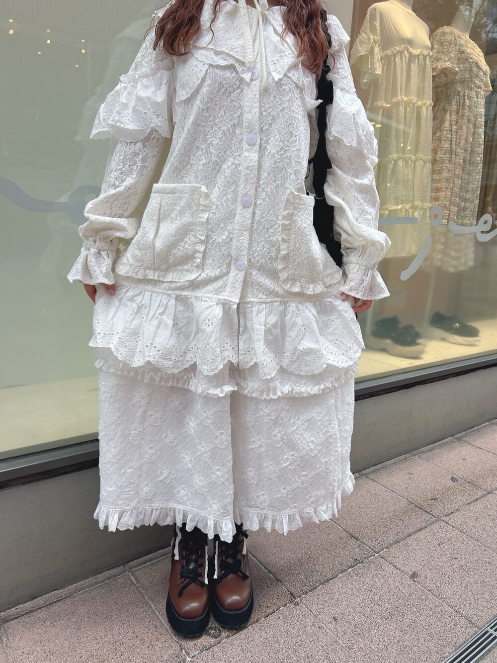 ホワイト系のテーラードジャケット、ホワイト系のスカート、ブラック系のショルダーバッグを着用したレディースの夏コーディネートの9枚目の写真