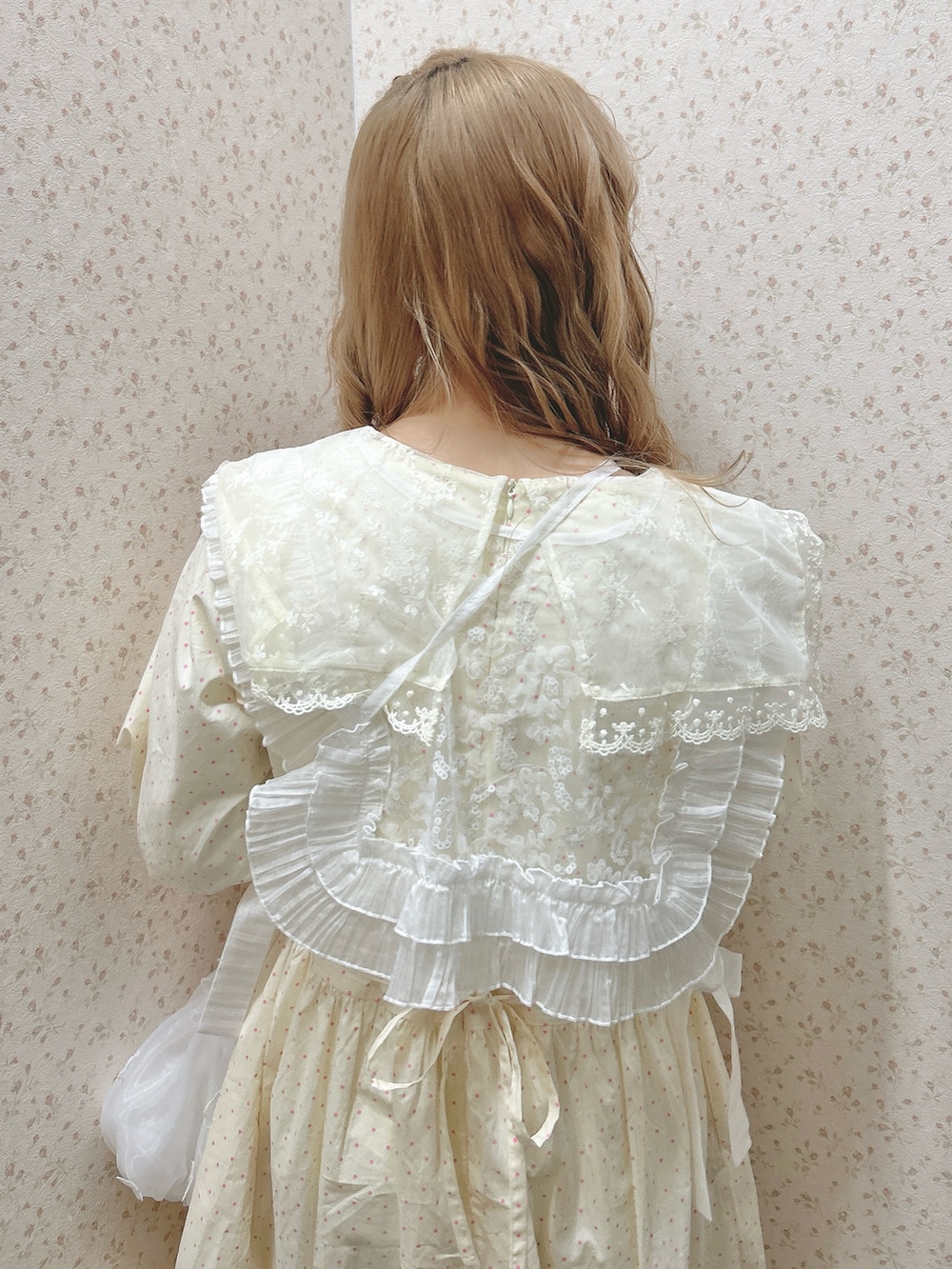 ベージュ系のワンピース、ホワイト系のハンドバッグ、ホワイト系のスニーカーを着用したレディースの冬コーディネートの6枚目の写真