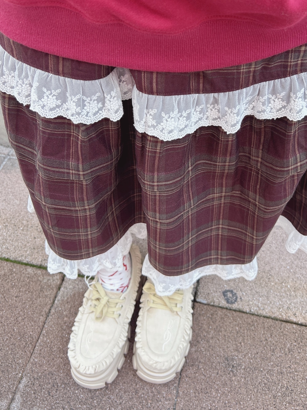 レッド系のスウェット、ホワイト系のシャツ/ブラウス、ブラウン系のスカートを着用したレディースの秋コーディネートの9枚目の写真