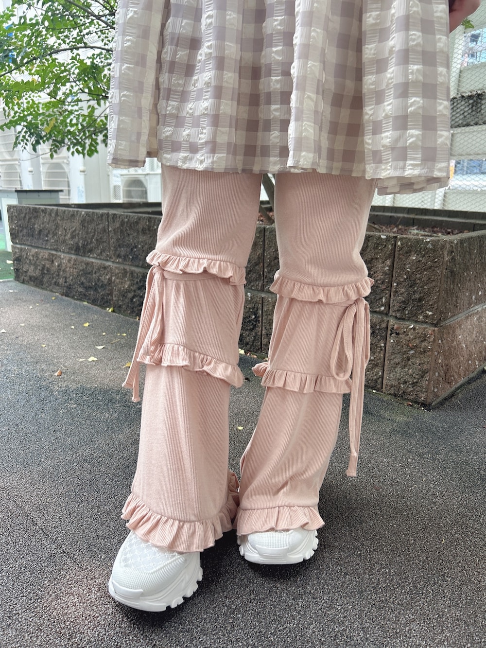 ピンク系のスウェットパンツ、ホワイト系のスニーカー、ベージュ系のキャミソールを着用したレディースの夏コーディネートの9枚目の写真