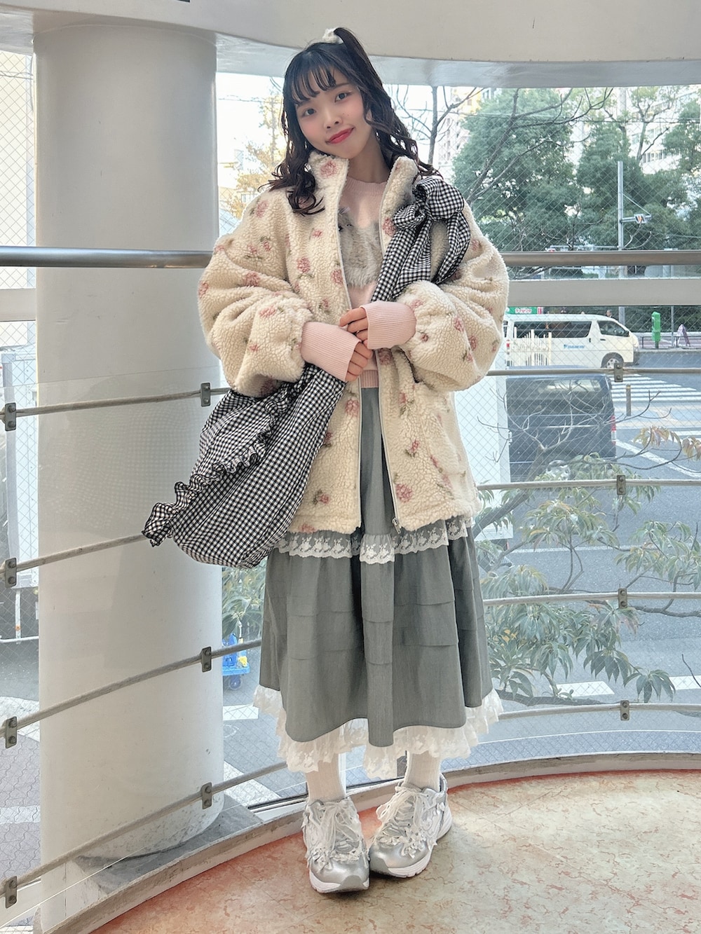 ピンク系のブルゾン、ピンク系のニット/セーター、グレー系のスカートを着用したレディースの冬コーディネートの3枚目の写真