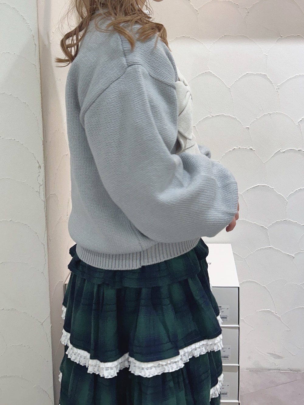 ブルー系のニット/セーター、ホワイト系のシャツ/ブラウス、グリーン系のスカートを着用したレディースの秋コーディネートの6枚目の写真