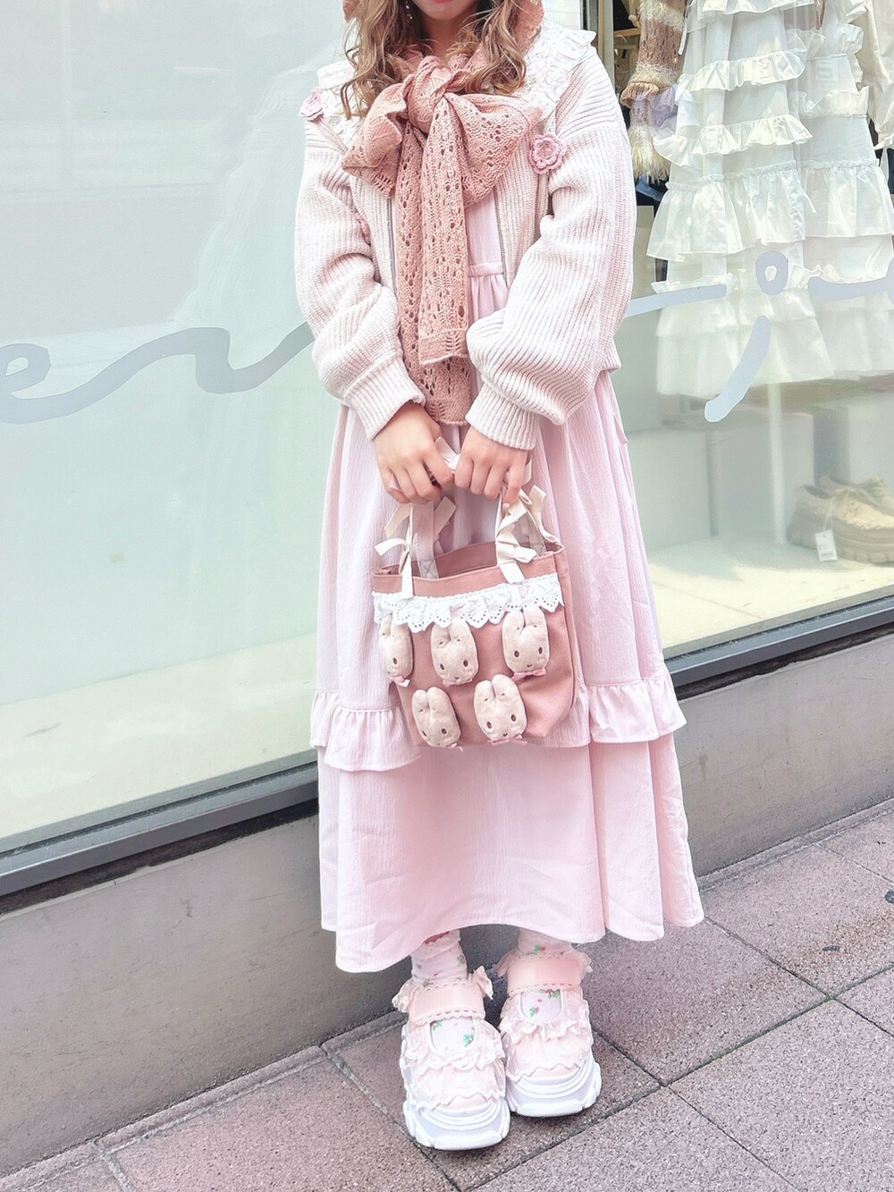 ピンク系のワンピース、ホワイト系のカーディガン/ボレロ、ピンク系のハンドバッグを着用したレディースの秋コーディネートの9枚目の写真