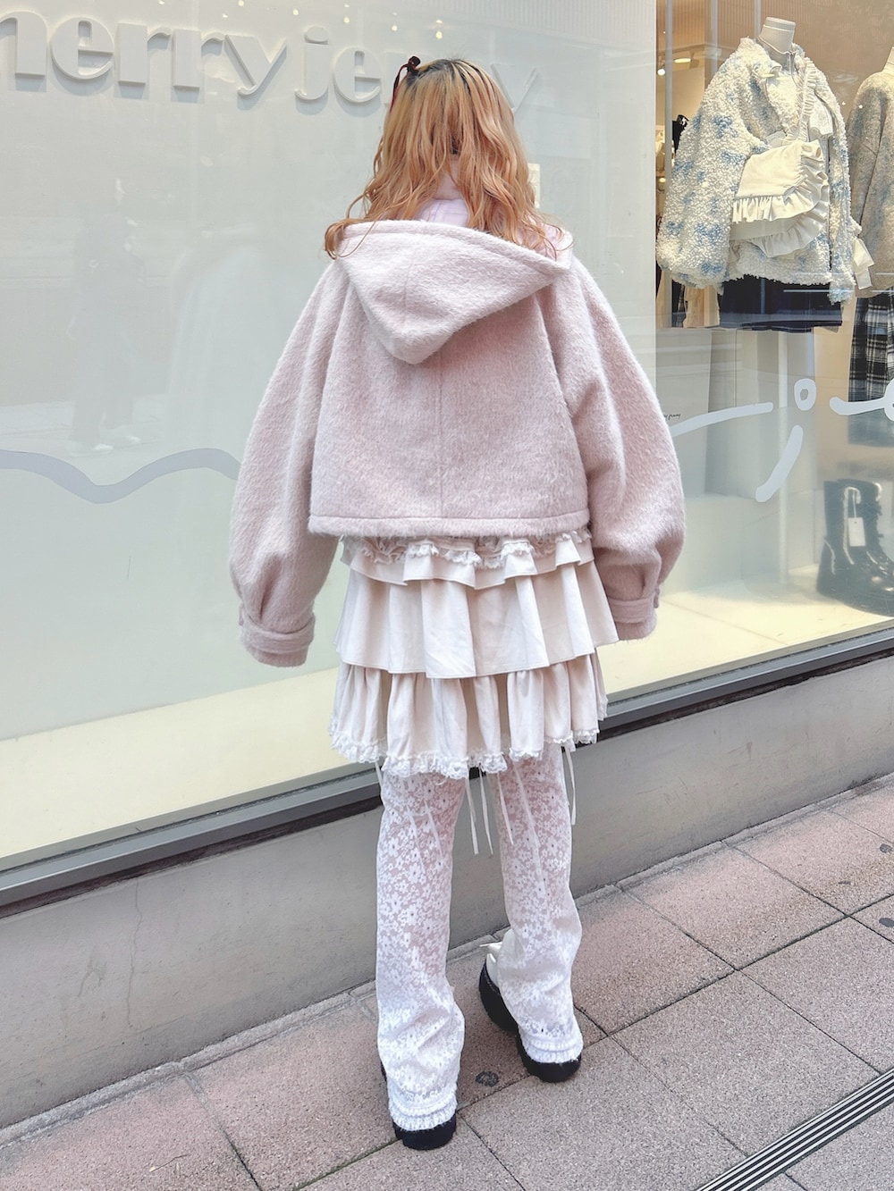 ホワイト系のスカート、ピンク系のダッフルコート、ホワイト系のカーディガン/ボレロを着用したレディースの秋コーディネートの3枚目の写真