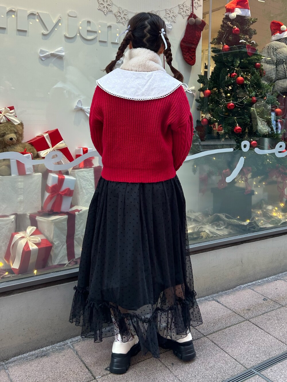 ホワイト系のブルゾン、レッド系のニット/セーター、ブラック系のワンピースを着用したレディースの冬コーディネートの8枚目の写真