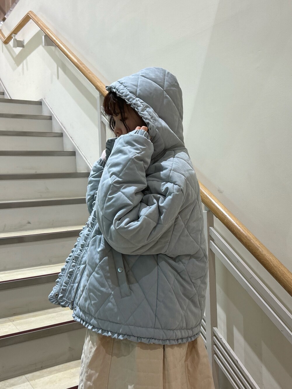 ピンク系のニット/セーター、ブルー系のダウンジャケット/コート、ホワイト系のワンピースを着用したレディースの冬コーディネートの7枚目の写真