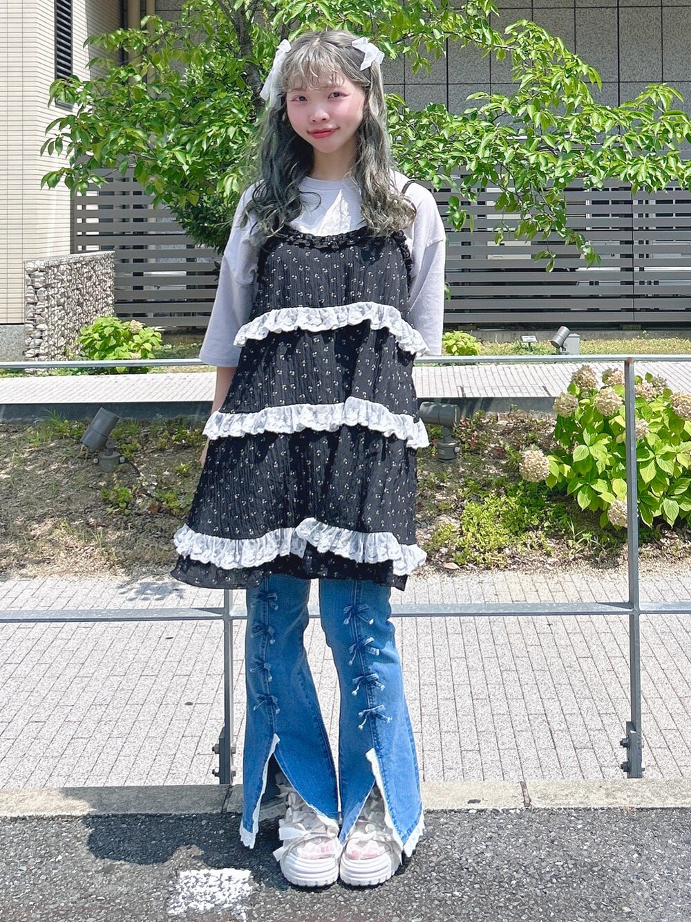 ブラック系のチュニック、パープル系のTシャツ/カットソー、ブルー系のデニムパンツを着用したレディースの夏コーディネートの3枚目の写真