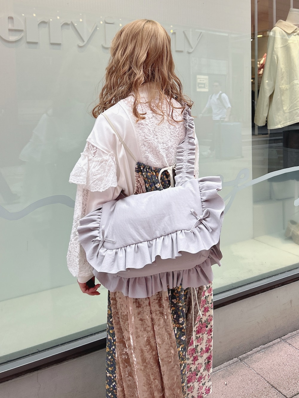 ホワイト系のジャージ、ピンク系のワンピース、ブルー系のショルダーバッグを着用したレディースの秋コーディネートの7枚目の写真