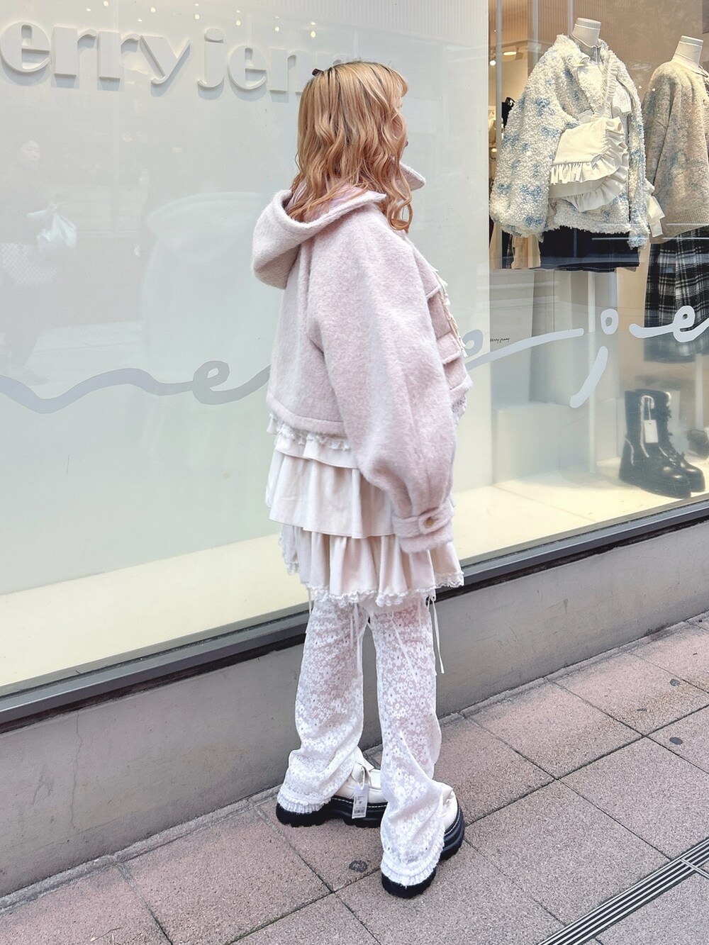 ホワイト系のスカート、ピンク系のダッフルコート、ホワイト系のカーディガン/ボレロを着用したレディースの秋コーディネートの2枚目の写真